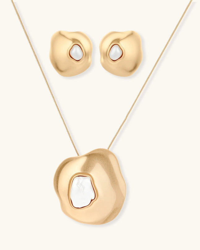 Schmuckset in mattem Gold mit organisch geformtem Anhänger und Ohrringen, jeweils mit weißer Barockperle