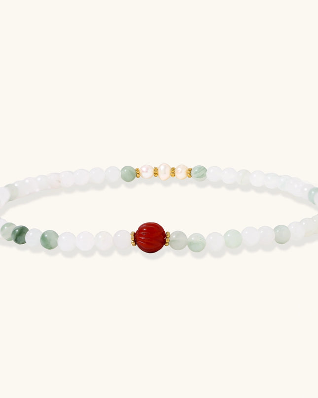Jade-Perlenarmband mit roter geschnitzter Achat-Lotusblüte und vergoldeten Details, ausgebreitet