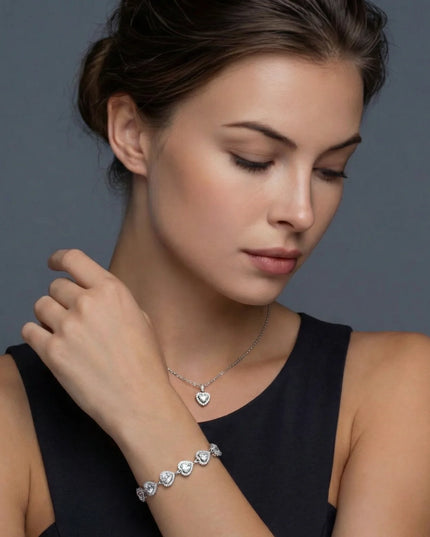 Frau trägt Herz-Halskette, Armband, Ohrstecker und Ring aus Silber