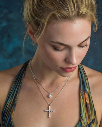 Frau trägt silberne Kreuz-Halskette und Solitär-Kette im Layering-Look