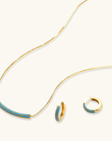 Türkis-Schmuckset in Gold mit geschwungenem Anhänger und kleinen Creolen, seitlich fotografiert