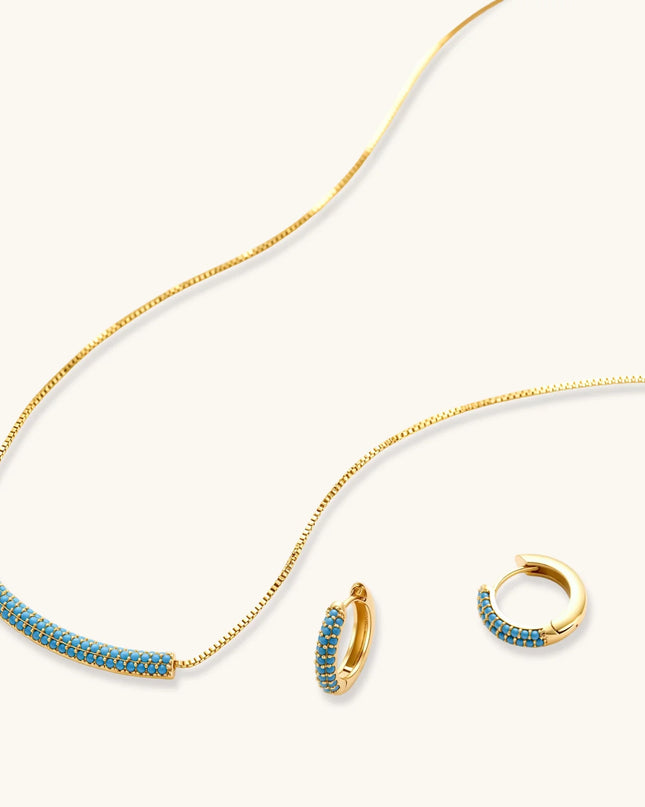 Türkis-Schmuckset in Gold mit geschwungenem Anhänger und kleinen Creolen, seitlich fotografiert